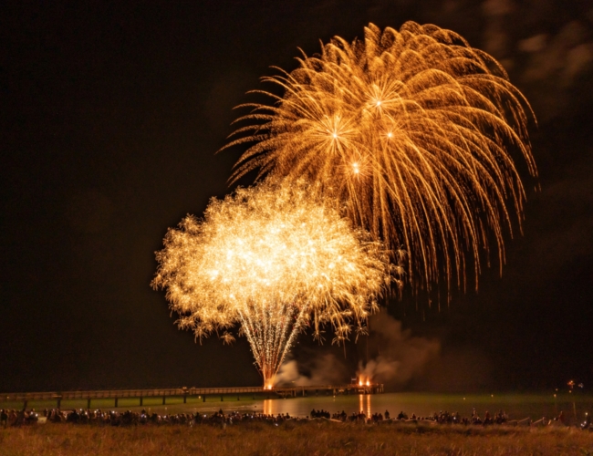 Ein goldenes Feuerwerk zum Seebrückenfest 2024, gezündet auf der Seebrücke und funkelndes Wasser.