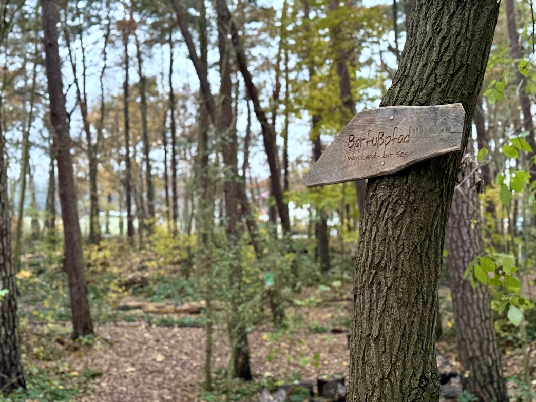 Das Holzschild für den Barfusspfad als Wegweiser